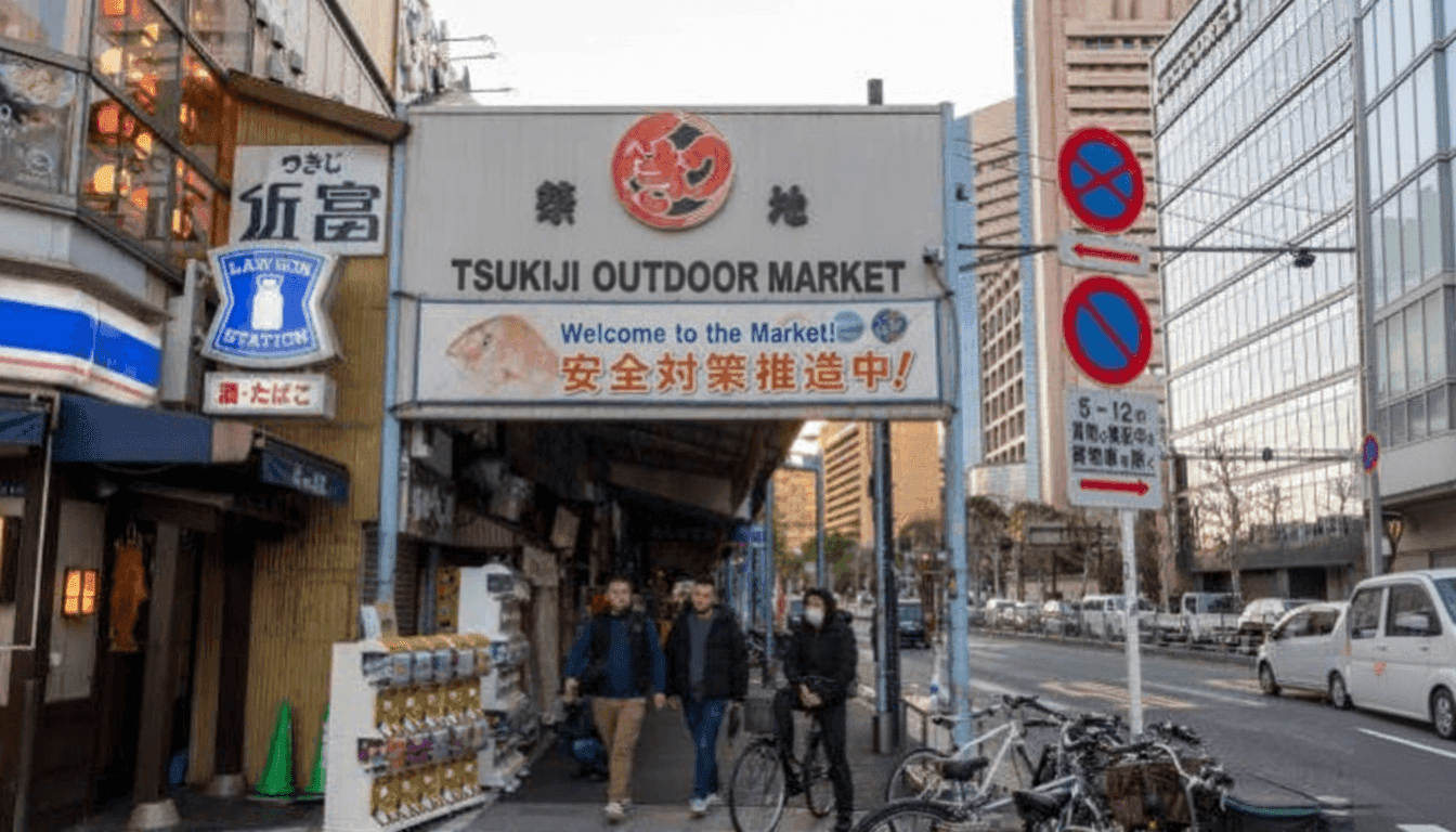 Fresh sushi and seafood served at a Tsukiji Outer Market counter with chefs preparing plates at an outdoor stall, Tokyo